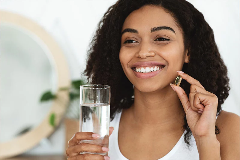 Smiling woman taking a natural supplement