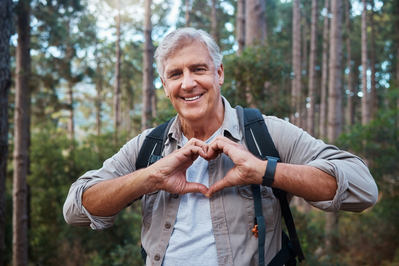 man forming heart with hands