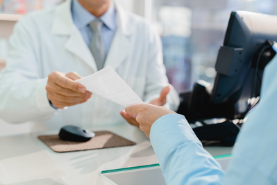 pharmacist handing paper to patient