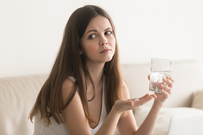 unhappy woman with pill