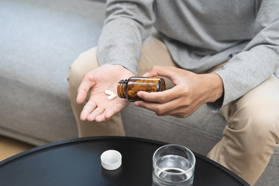 man pouring supplements into hand