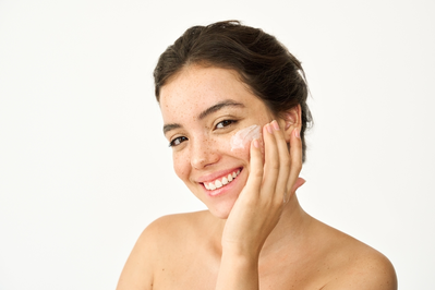 woman putting moisturizer on face