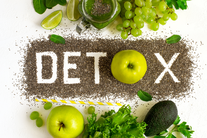 detox spelled out in chia seeds surrounded by fruits and vegetables